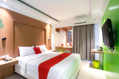 a hotel room with a bed and a tv at RedDoorz Apartment at Bogor Valley in Bogor