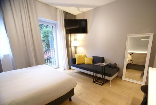 una camera con letto, divano e specchio di Fingerprint Tree Apartments - Cozy a Zagabria