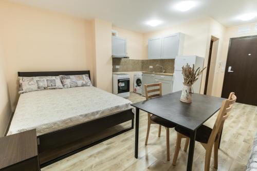 a bedroom with a bed and a table and a kitchen at BLOCK 531 ApartHouse BLOCK 533 in Sofia