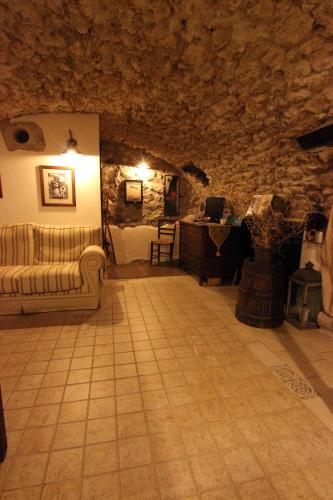 a living room with a couch and a table in a stone wall at Residenza La Torre in Santo Stefano di Sessanio
