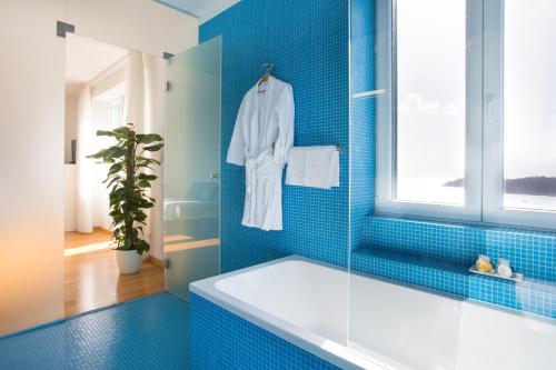 een blauw betegelde badkamer met een bad en een raam bij Villa Paulina in Dubrovnik
