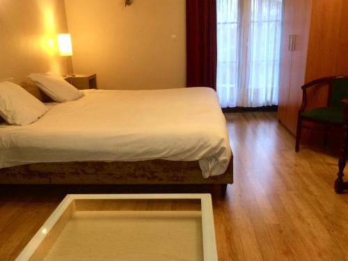 a hotel room with a bed and a window at Hotel La Venerie in Virton