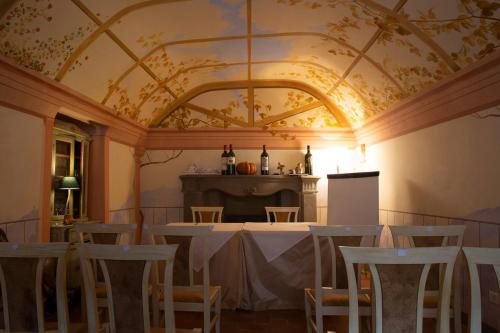 ルッカにあるホテル アッラ コルテ デッリ アンジェリの天井のある客室で、テーブルと椅子が備わります。