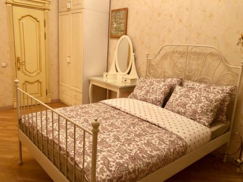 モスクワにあるKvartira Svobodna near Neskuchniy Sadのベッドルーム1室(鏡付きベッド1台、テーブル付)
