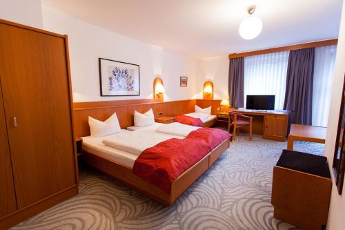 ハノーファーにあるHotel Atlantaのベッドとデスクが備わるホテルルームです。