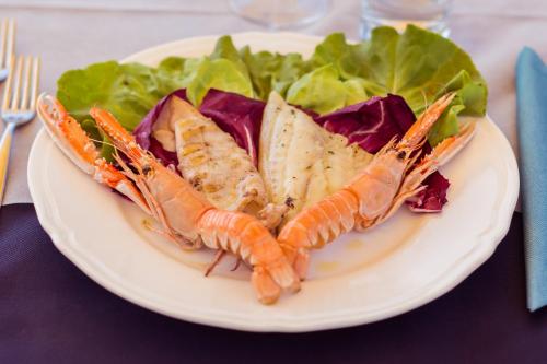 a plate of food with shrimp and salad on a table at Villaggio Mare Si in Follonica