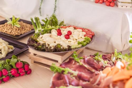 a buffet of food with meat and vegetables on a table at Villaggio Mare Si in Follonica