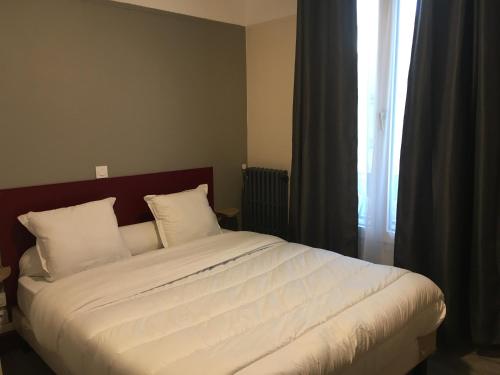 - une chambre dotée d'un grand lit avec des draps blancs et une fenêtre dans l'établissement HOTEL DE STRASBOURG, à Aulnay-sous-Bois