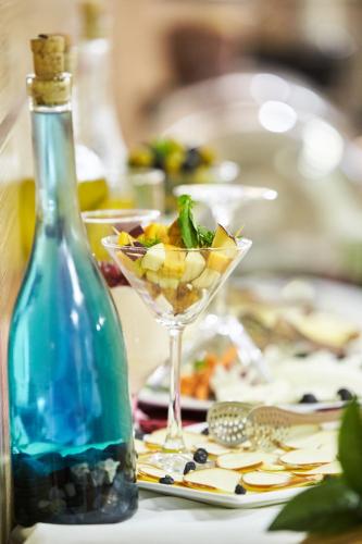 a bottle of wine and a martini glass on a table at NOBEL Hotel in Baku