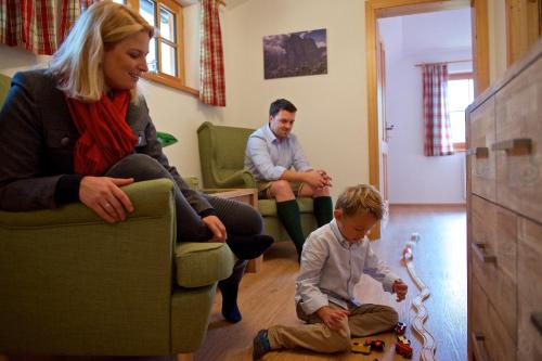 a woman and a child playing with a toy at Rainbachhütte-Waldgut Granig in Glödnitz