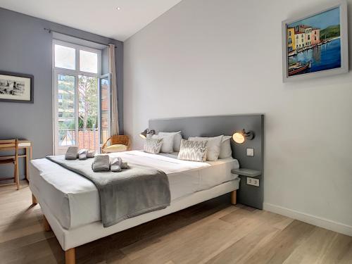 une chambre avec un grand lit blanc dans une pièce dans l'établissement Nestor&Jeeves - PALAIS MARIE PRESTIGE - Central - Close sea, à Nice