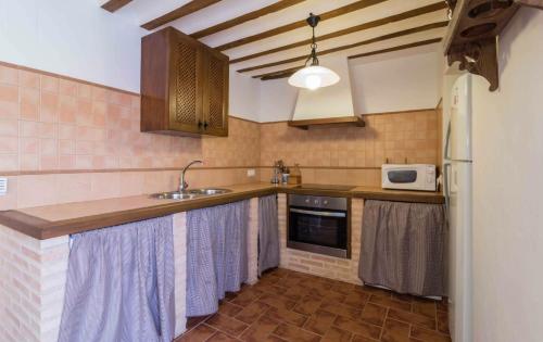 a kitchen with a sink and a microwave at EL CHARQUILLO CR in Canaleja