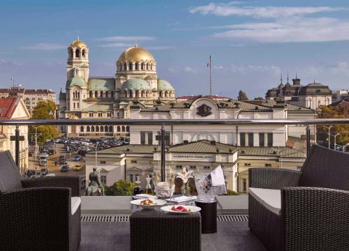 a table with plates of food on a balcony with a building at InterContinental Sofia, an IHG Hotel in Sofia