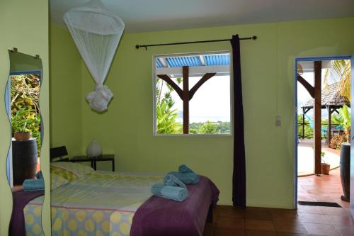 a bedroom with a bed in a room with a window at TI coin de paradis Frangipanier in Le Diamant