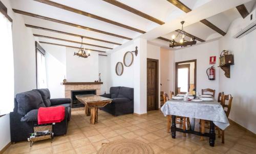 a living room with a table and chairs and a fireplace at EL CHARQUILLO CR in Canaleja