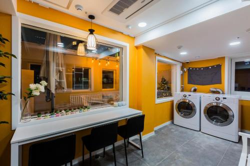 a yellow laundry room with a washer and dryer at MJ Stay 2 in Seoul