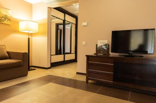 a living room with a flat screen tv and a couch at Belle Royalle in Lisarnya