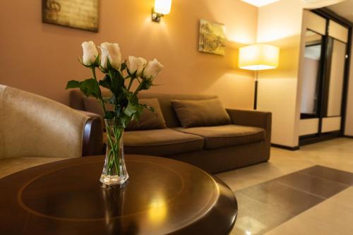 a vase of flowers on a table in a living room at Belle Royalle in Lisarnya