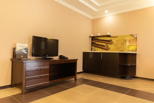 a living room with a tv on a wooden dresser at Belle Royalle in Lisarnya