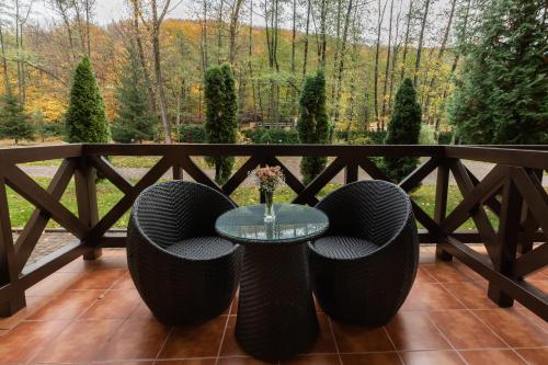 a patio with a glass table and wicker chairs at Belle Royalle in Lisarnya