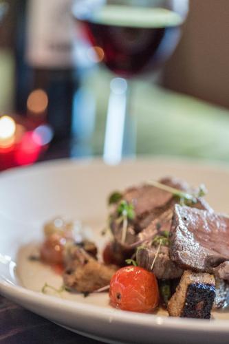 a plate of food with meat and vegetables on a table at Aubrey Park Hotel in Hemel Hempstead