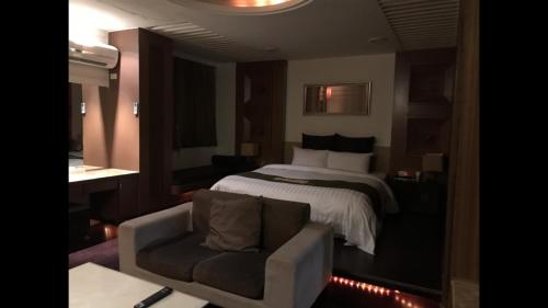a hotel room with a bed and a chair at Yatelanda Motel in Shalu