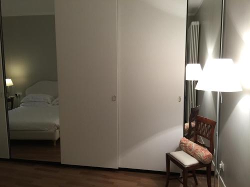 a bedroom with a bed and a chair and a mirror at La Casa di Paola in Lovere
