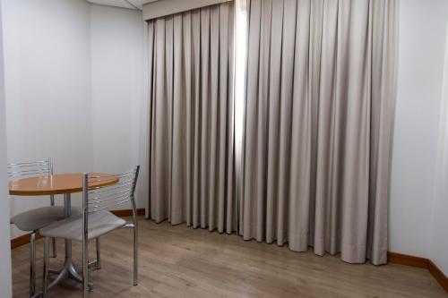 a table and chairs in a room with curtains at Di Giulio Hotel in São José dos Campos