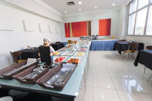 a restaurant with a long table with food on it at Di Giulio Hotel in São José dos Campos