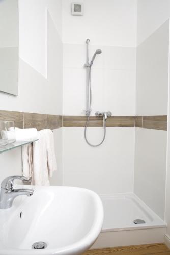 a white bathroom with a tub and a sink at Ferienwohnungen Schlei 42 in Schleswig