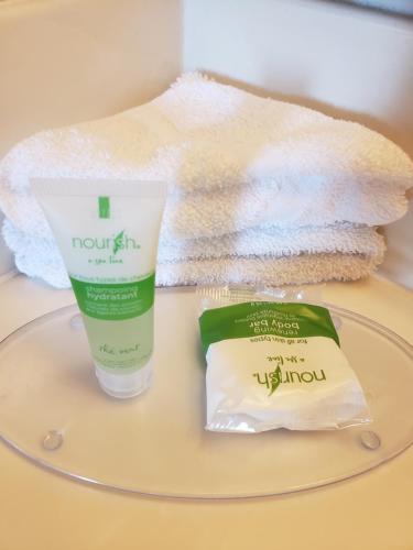 a pile of towels and a bottle of moisturizing moisturizing cream and a container at SkyView Swift Current in Swift Current