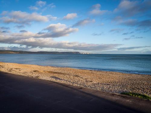 a beach with a body of water and the ocean at Channel View Guest House in Weymouth