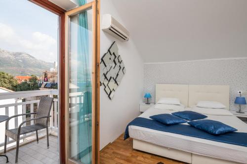 a bedroom with a bed and a balcony at Villa Voinic 2 in Cavtat