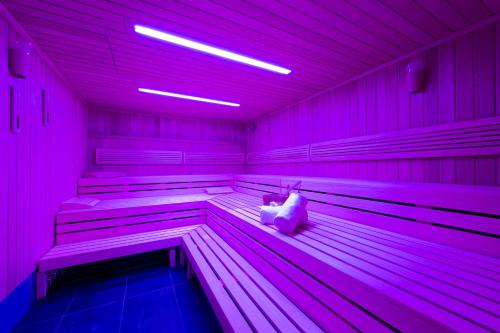 a room with pink lights and benches in a building at Welcome Hotel Neckarsulm in Neckarsulm