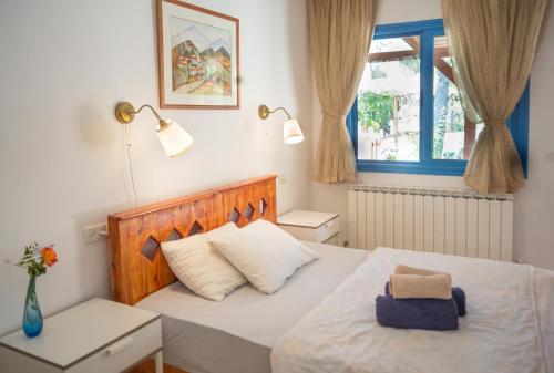 a bedroom with a bed with a wooden headboard and a window at House On The Mountain in Neve Ativ