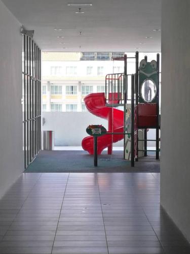 a room with a playground with a red slide at Rumah Cik Ani in Shah Alam