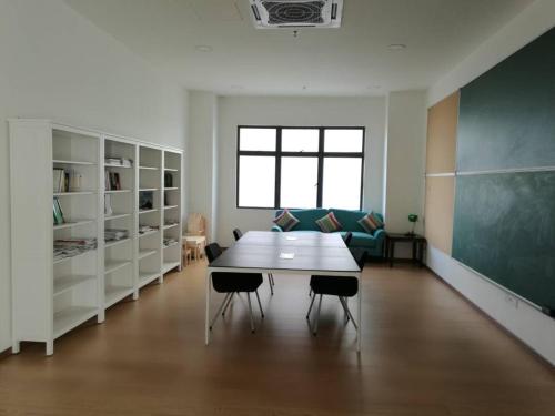 a classroom with a table and chairs and a chalkboard at Rumah Cik Ani in Shah Alam