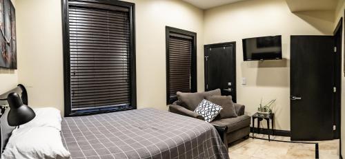 a bedroom with a bed and a couch and a tv at Ultra lux apartment steps from Brown and RISD in Providence