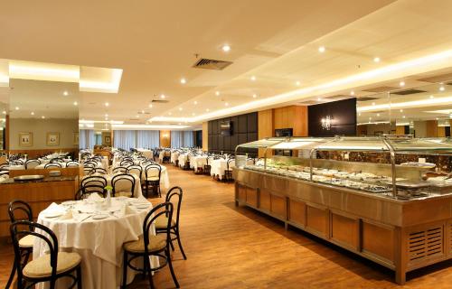 a restaurant with tables and chairs and a buffet at Windsor Florida Hotel in Rio de Janeiro
