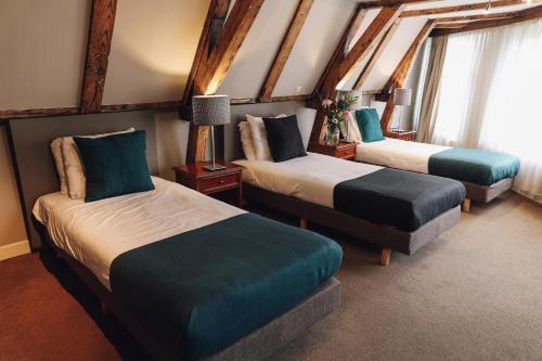 two beds in a room with two windows at Hotel Corner House in Amsterdam