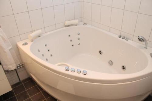 a large white bath tub in a bathroom at Lindesbergs Stadshotell in Lindesberg