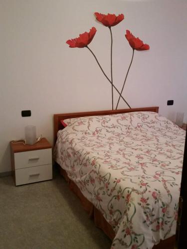 een slaapkamer met een bed met rode bloemen aan de muur bij Morbegno house in Morbegno