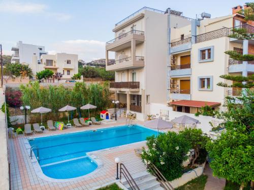 an apartment with a swimming pool in front of a building at Eltina Hotel in Rethymno Town