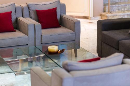 a living room with two chairs and a glass coffee table at Eltina Hotel in Rethymno Town