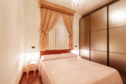 a bedroom with a bed with a window and a chandelier at il casseretto in Ascoli Piceno