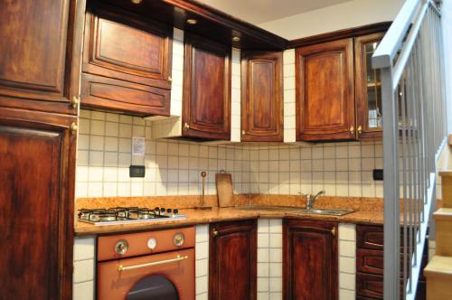 a kitchen with wooden cabinets and a sink and a stove at Ai Vellutai in Ala