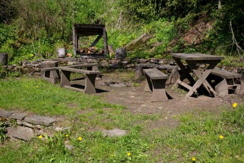 a group of picnic tables and a stone wall at Pension Arnika in Modrava