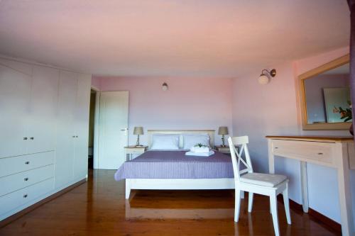 a bedroom with a bed and a chair in it at Nicopolis Villa in Vráchos