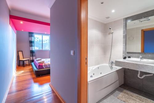 un bagno con vasca e lavandino di Apartamento Serramar , Vistas deslumbrantes a Calheta