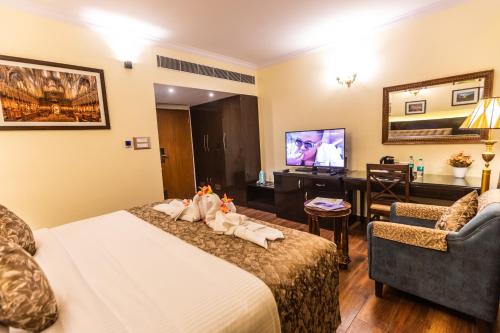 a hotel room with a bed and a tv at Hotel Paramos Inn in Bengaluru